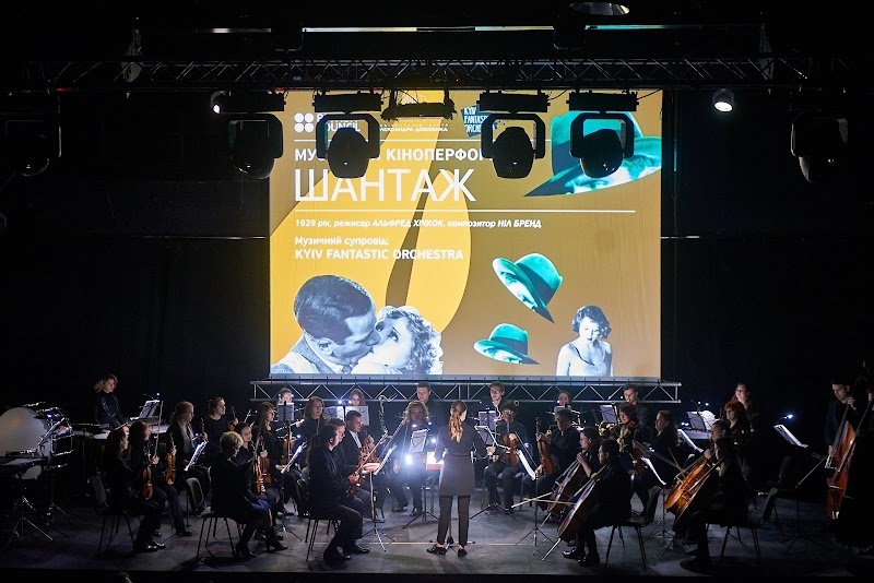 Un'orchestra si esibisce sul palco con musicisti che suonano vari strumenti.