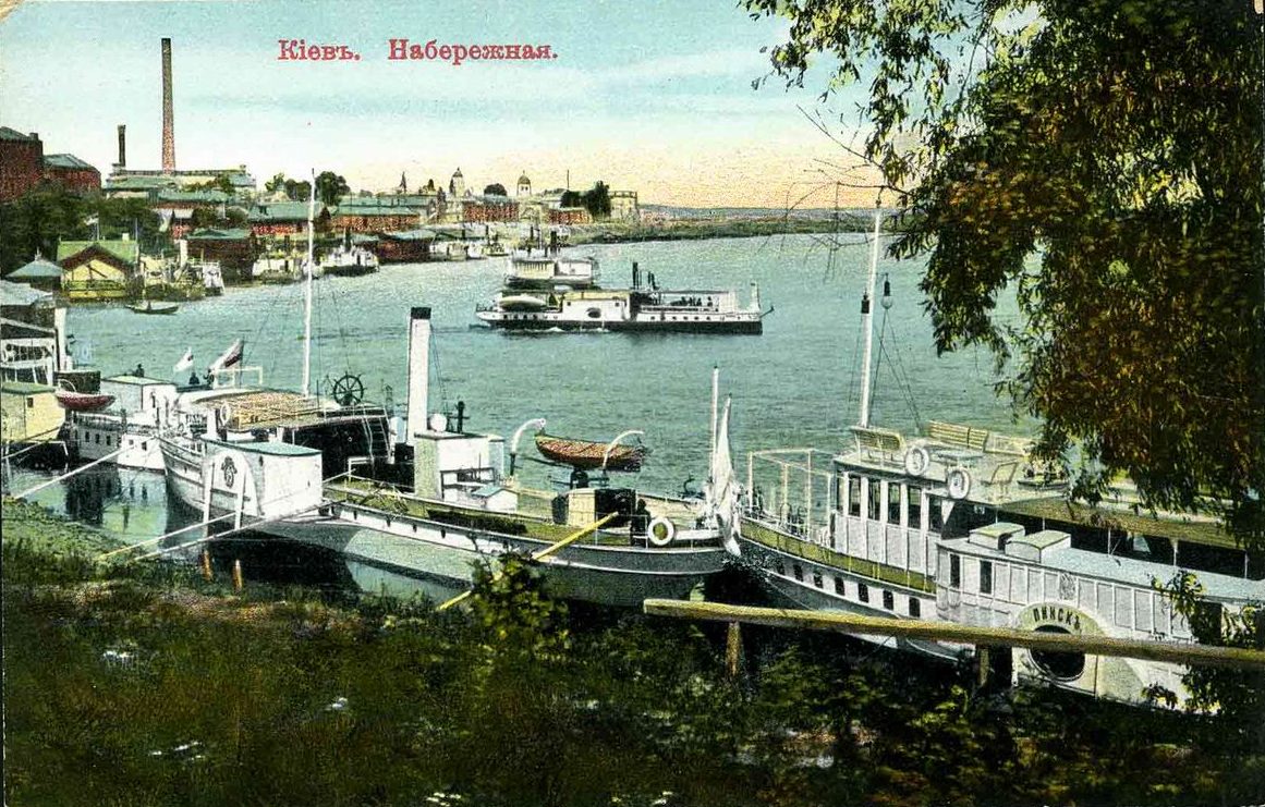 Mehrere Boote und Dampfer liegen am Ufer des Flusses fest.