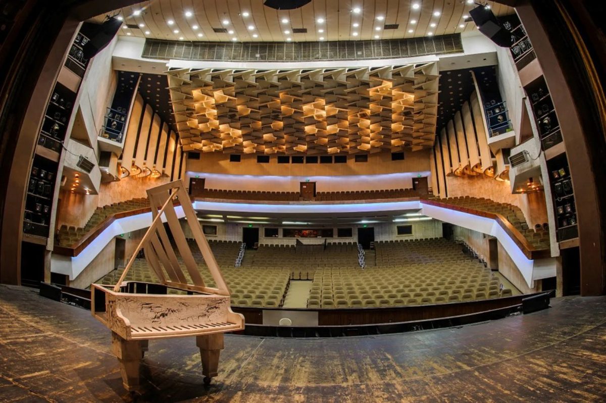 Vista del auditorio desde el escenario, con asientos vacíos para el público.