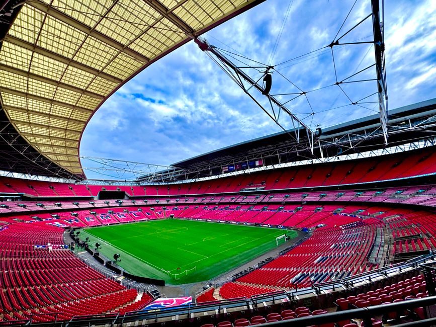 Το στάδιο Wembley διαθέτει έναν μεγάλο πράσινο αγωνιστικό χώρο και κόκκινες θέσεις.