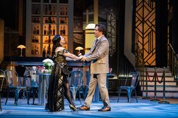 Due attori recitano una scena romantica sul palco in costumi eleganti.