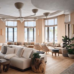 Un lounge moderno con divani comodi e grandi finestre che si affacciano sulla spiaggia.