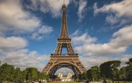 La Torre Eiffel si erge sotto un cielo blu con nuvole.