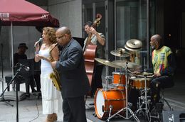 Una band jazz suona con una vocalist e musicisti che suonano vari strumenti.
