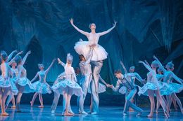 I ballerini si esibiscono sul palco in costumi bianchi.