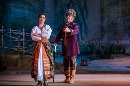 Schauspieler sind auf der Bühne in traditionellen ukrainischen Kostümen abgebildet.