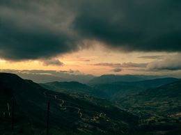 Am Horizont sind Berge unter Wolken bei Sonnenuntergang sichtbar.