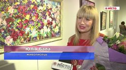 L'esposizione presenta opere dell'artista Yuliya Bala, che tiene un mazzo di fiori.