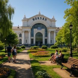 На алеї парку видно людей, які прогулюються біля будівлі з написом 'Boksan'.