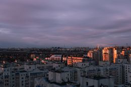 L'orizzonte presenta edifici moderni sotto un cielo crepuscolare con nuvole.