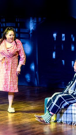 Due attori sono sul palco, uno in accappatoio e l'altro in una coperta.