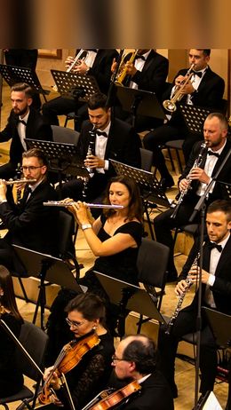 Músicos de la orquesta INSO-Lviv están actuando en el escenario con varios instrumentos.