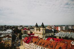Die Skyline zeigt Gebäude mit roten Dächern und eine Kirche mit zwei Türmen.
